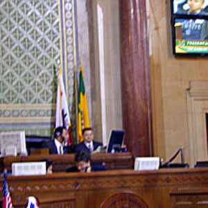 2002,   Sir Ian on the monitors as he addresses the Los Angeles City Council, 18 January 2002  - Photo by Keith Stern