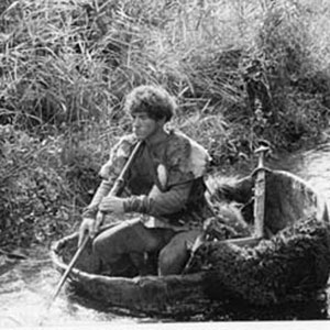 Roger the Bandit (Ian McKellen) paddling his kayak in an Irish backwater.