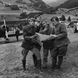 Gregory Peck with his young team of aircraftsmen planning to carry Allied aeroplane parts through occupied territory where they would be reassembled in order to bomb enemy targets.
<BR><BR><I>Peck kept himself privately in his caravan between shots, where he read and answered his mail.  He told me about his early days in theatre, where he had been happy just to sweep the stage.  He was now a huge movie star.  In our film he was not well-cast as an English army Colonel � he repeatedly addressed me as Loo-tenant: and when I repeatedly corrected his pronunciation (in UK we say Left-tenant), the director David Miller told me to shut up. Never forget Ian, Great Britain is only 5% of the world market.</I>