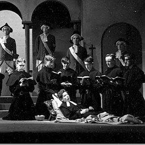 Deathbed scene.  In this scene the precept Low on his funeral couch he lies had presumably been borne in mind by the producer: the couch was in fact so low as not to be visible beyond the first few rows of the audience, with the result that the Father Provincials opening line of the scene brought with it a touch of the supernatural. -- The Boltonian, July 1958
