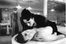 In the mortuary, Lady Anne (Kristin Scott Thomas) grieves over the body of her slaing husband as Richard approaches.